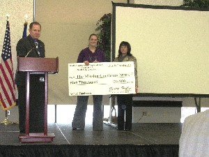 Presenting a check to The Mission Continues Fellowship Award recipient Natalie Williams (c) at the December meeting are John Rogers, chapter president-elect, and Cindy Heflin, chapter president.